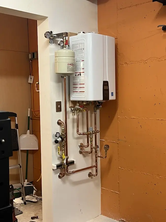 Plumbing technician inspecting water heater connections in Payson